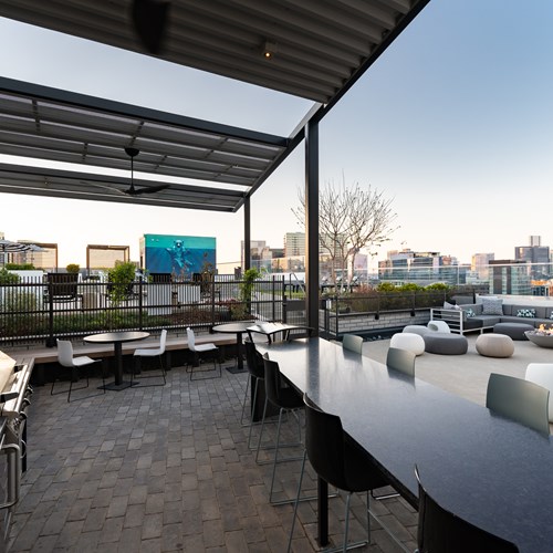 rooftop pool lounge with grills, seating, pool and views